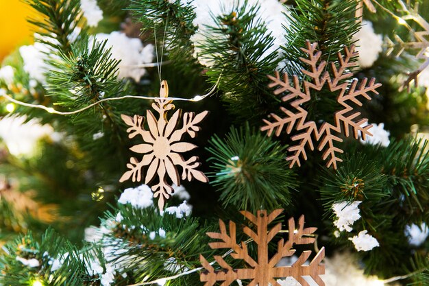 New year toys in the shape of wooden snowflakes on christmas tree. New year decorations