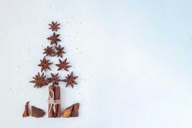 New year tree made of stars anise and cinnamon sticks, white background, top view, copy space, idea for a Christmas card