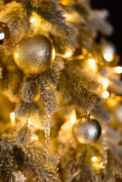 Photo new year vertical screensaver closeup round toys among christmas tree branches and garlands