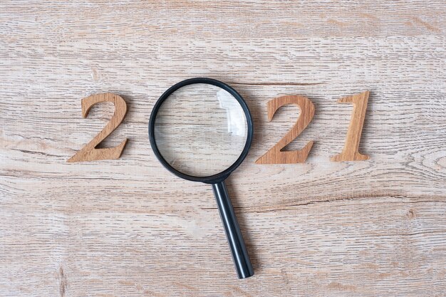 New year with magnifying glass and wooden number