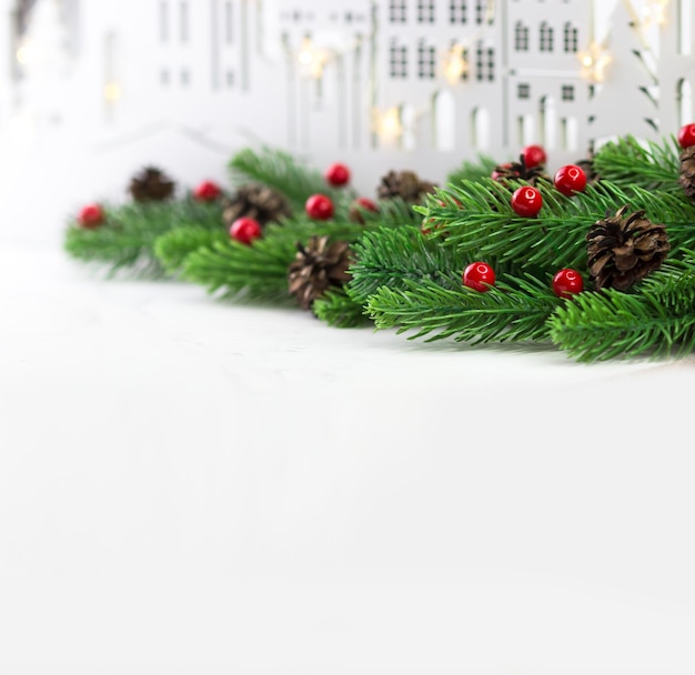 New Years banner Fir branches on the background of a wooden city Space for text