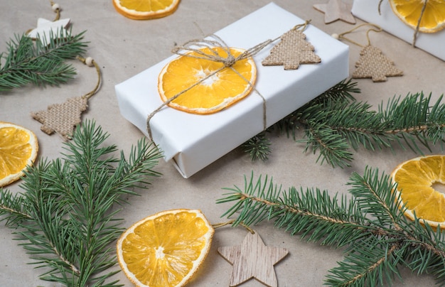 New Years composition On beige craft paper gift boxes dry orange slices pine cones