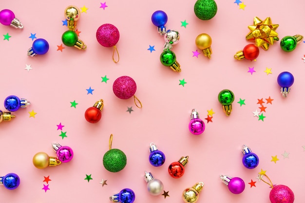 Новогодняя композиция разноцветные украшения шары и звезды на пастельно-розовом фоне рождество зима ...
