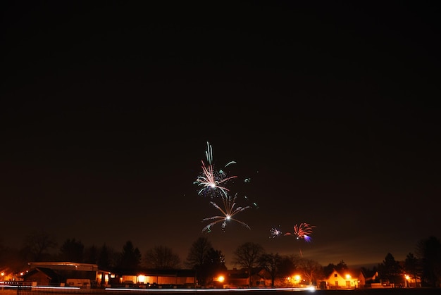 Празднование Нового года в деревне с красочным фейерверком ночью