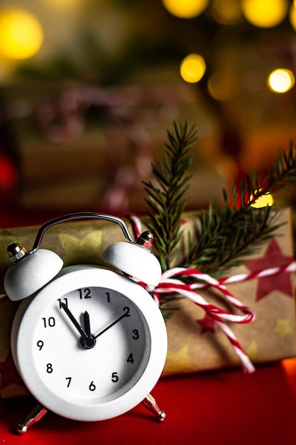 New Years Eve. Vertical greeting card happy holiday alarm clock five to midnight and craft gifts, bokeh, soft focus, close-up