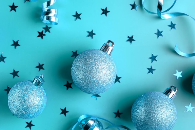 New Years frame of glittery gold baubles stars streamers Above view on a blue background Toned picture