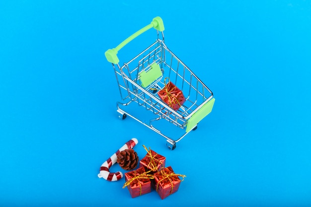 New Years gifts concept. Basket and christmas accessories. Christmas Shopping Cart With Gifts.