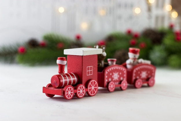 Foto carta di auguri di capodanno con una decorazione natalizia di un treno per bambini rosso