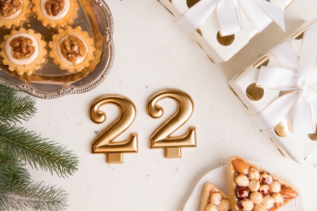 New Years holiday concept. Number 22 on a light background next to a sweet cookie