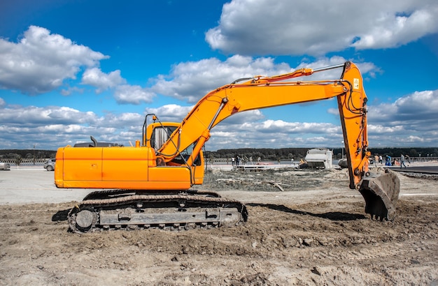 New yellow excavator working on the ground.