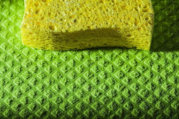 New yellow sponge on green dishcloth