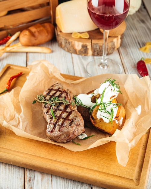 New york beef steak with baked potatoes and sour cream