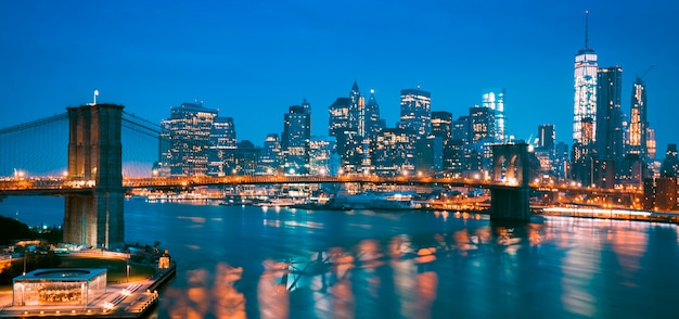 New york city manhattan midtown in de schemering met brooklyn bridge.