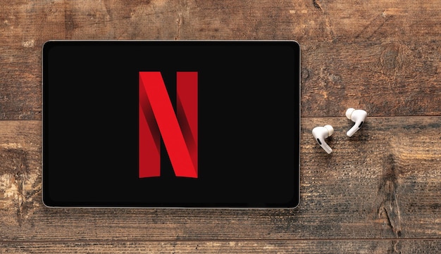 Foto new york usa 25 november 2022 netflix-logo op apple ipad en oortjes netflix is wereldwijde aanbieder van streaming films en tv-series