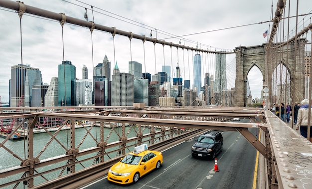 NEW YORK, USA - Apr 29, 2016: Cars crossing the Brooklyn Bridge in New York, Manhattan skyline in background