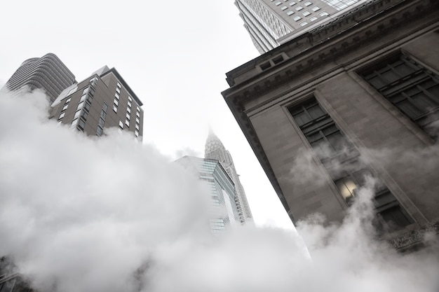 Photo new york, usa - may 03, 2016: empire state building. manhattan street scene. cloud of vapor from the subway on the streets of manhattan in nyc. typical view of manhattan