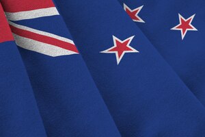 New zealand flag with big folds waving close up under the studio light indoors the official symbols and colors in banner
