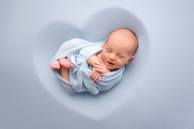 Photo newborn baby in a blue cocoon. high quality photo