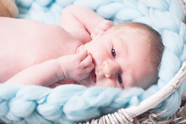 Photo newborn baby on blue giant crochet blanket look up