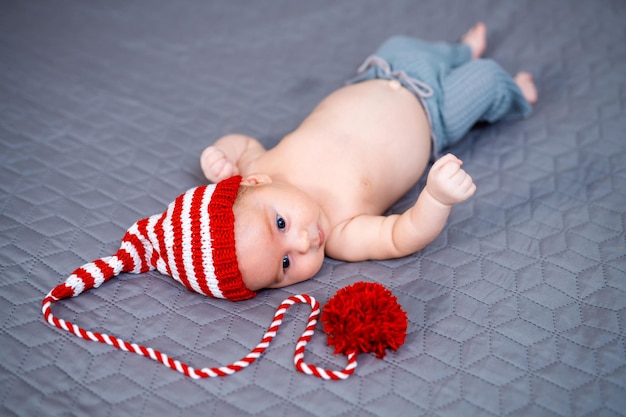Newborn baby boy in gnome costume Christmas photo of infant in ctriped cap New Year concept