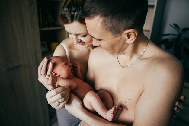 Newborn baby boy in the hands of parents