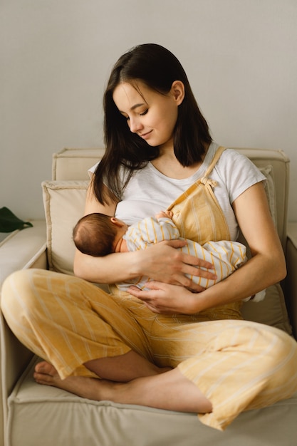 Newborn baby boy sucking milk from mother's breast