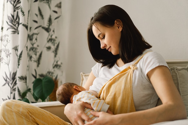 Newborn baby boy sucking milk from mother's breast