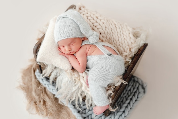 Newborn baby boy wearing a knitted soft blue jumpsuit