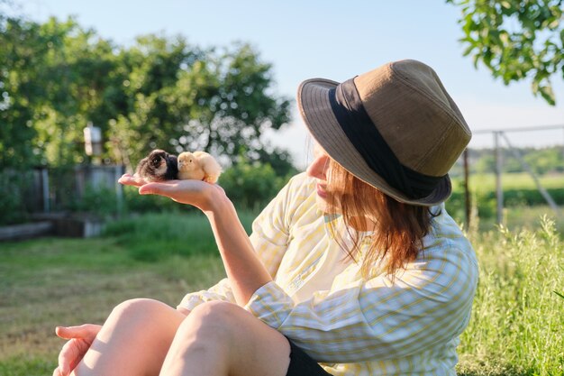 Newborn baby chicks on hand of farmer woman