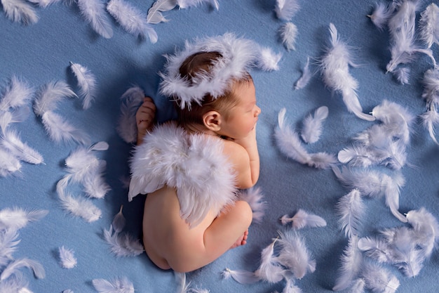 天使の羽を持つキューピッドの衣装で生まれたばかりの赤ちゃん