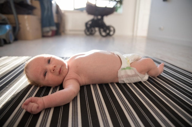 A newborn baby in a diaper lying on his back