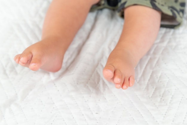 Newborn baby feet on creamy blanket closup of infant barefeet on white background