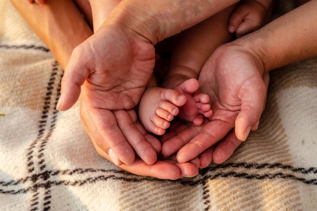 Newborn baby feet in family hands symbol of love