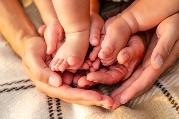 Newborn baby feet in family hands symbol of love