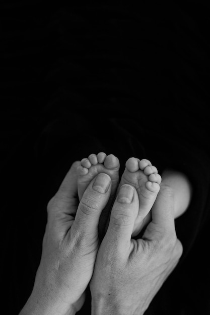 Newborn baby feet in father's hands. Newborn photography idea. Family photo concept photo, lifestyle