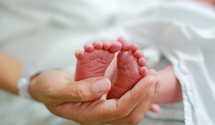 Photo newborn baby feet in mother hand.