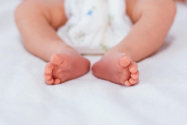 Foto piedi del neonato sulla coltre bianca concetto di maternità e infanzia