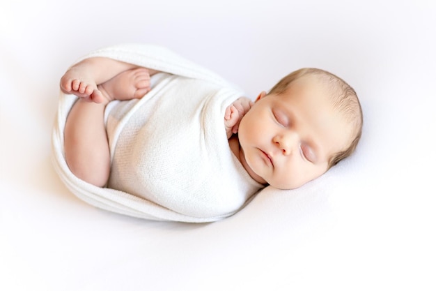 Foto bambina neonata in un cesto che dorme dolcemente su una coperta bianca con un ritratto di coniglietto di peluche