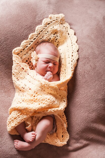 Photo newborn baby girl on the crochet blanket