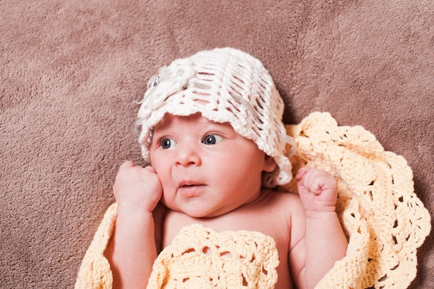 Newborn baby girl on the crochet blanket