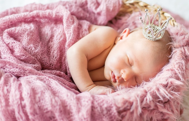 Newborn baby in a girl crown. Selective focus. people.