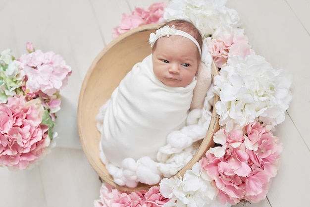 Newborn baby girl in flowers Healthy child Happy motherhood and parenting