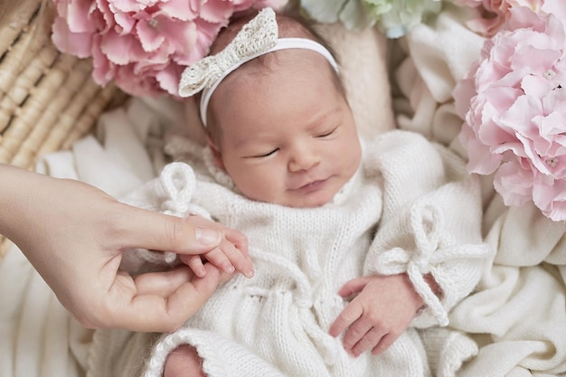 Newborn baby girl in flowers Healthy child Happy motherhood and parenting