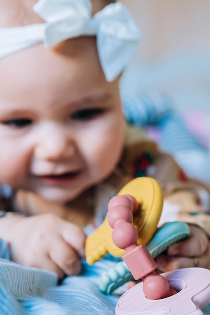 Newborn baby girl grabs the toy and plays with it