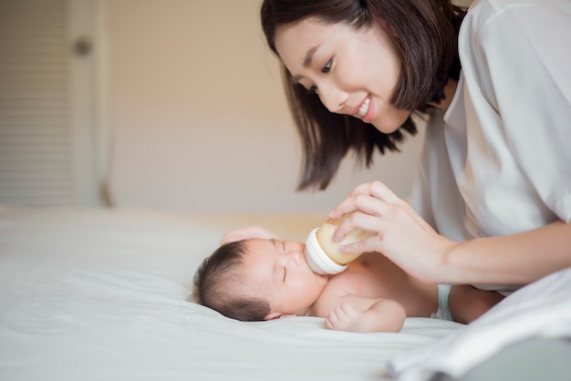 Newborn baby girl is drinking milk by  her mother 