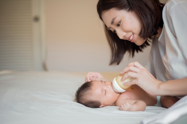 Newborn baby girl is drinking milk by her mother 