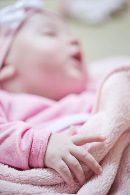 newborn baby girl sleeping in bed at home