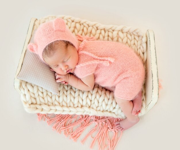 Newborn baby girl sleeping in a little bed