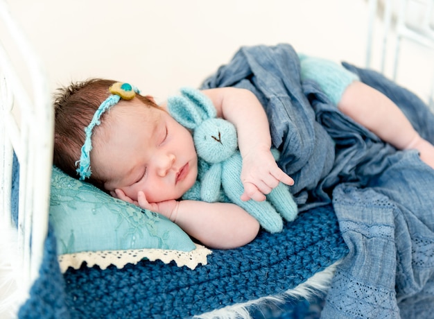 Newborn baby girl sleeping in a little bed