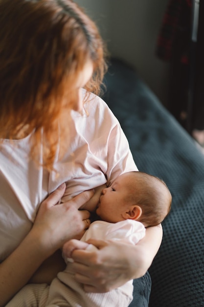 Newborn baby girl sucking milk from mothers breast Portrait of mom and breastfeeding baby Concept of healthy and natural baby breastfeeding nutrition